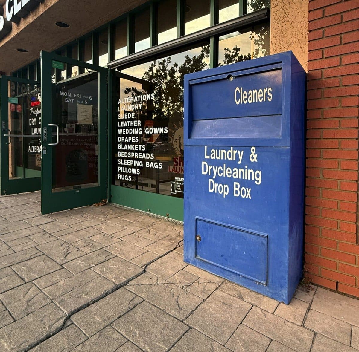 The blue Go Express laundry and dry cleaning drop box beside the shop door